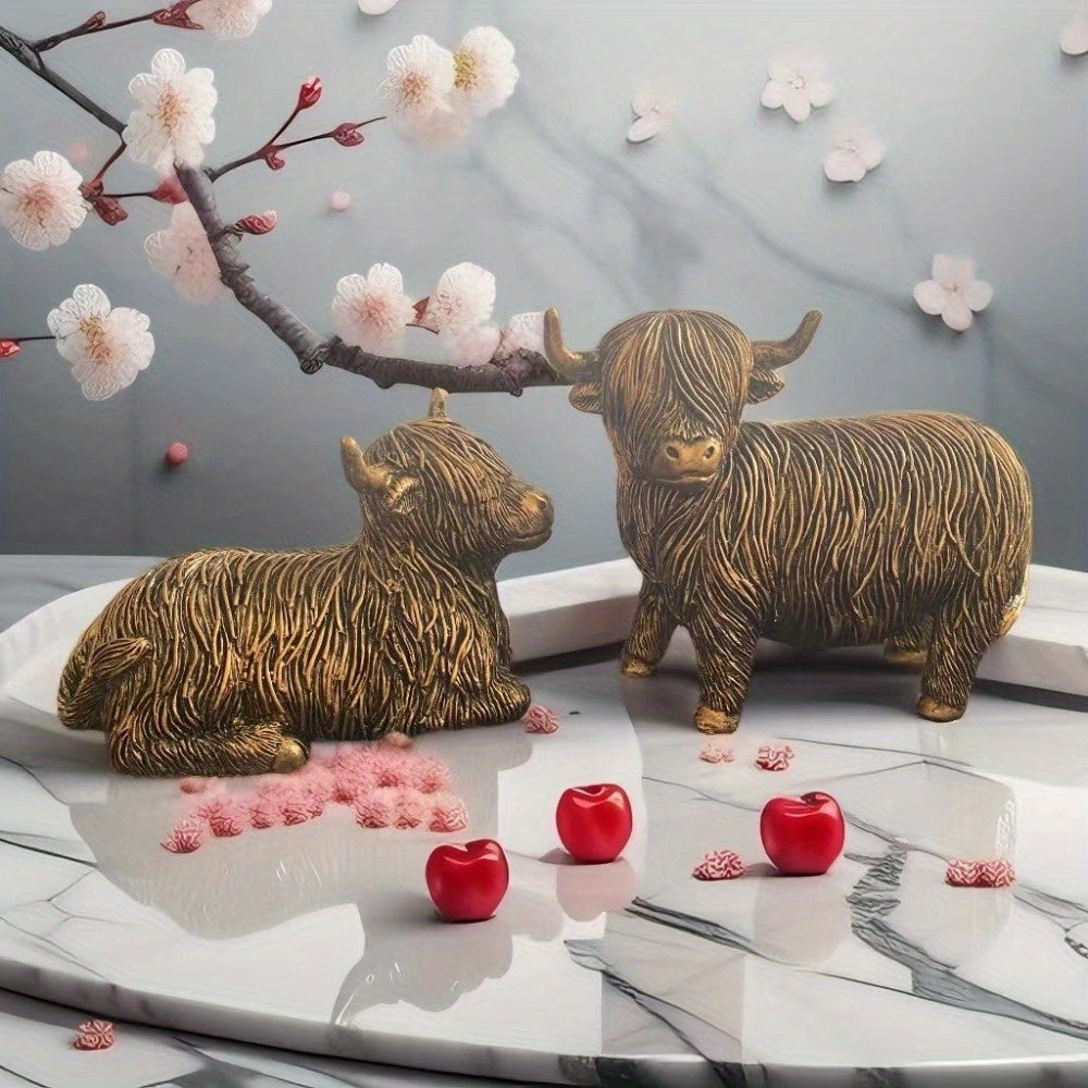 Eleganta skulpturer av höglandskon – Set med 2 figurer i harts med guldfärgad accentfinish