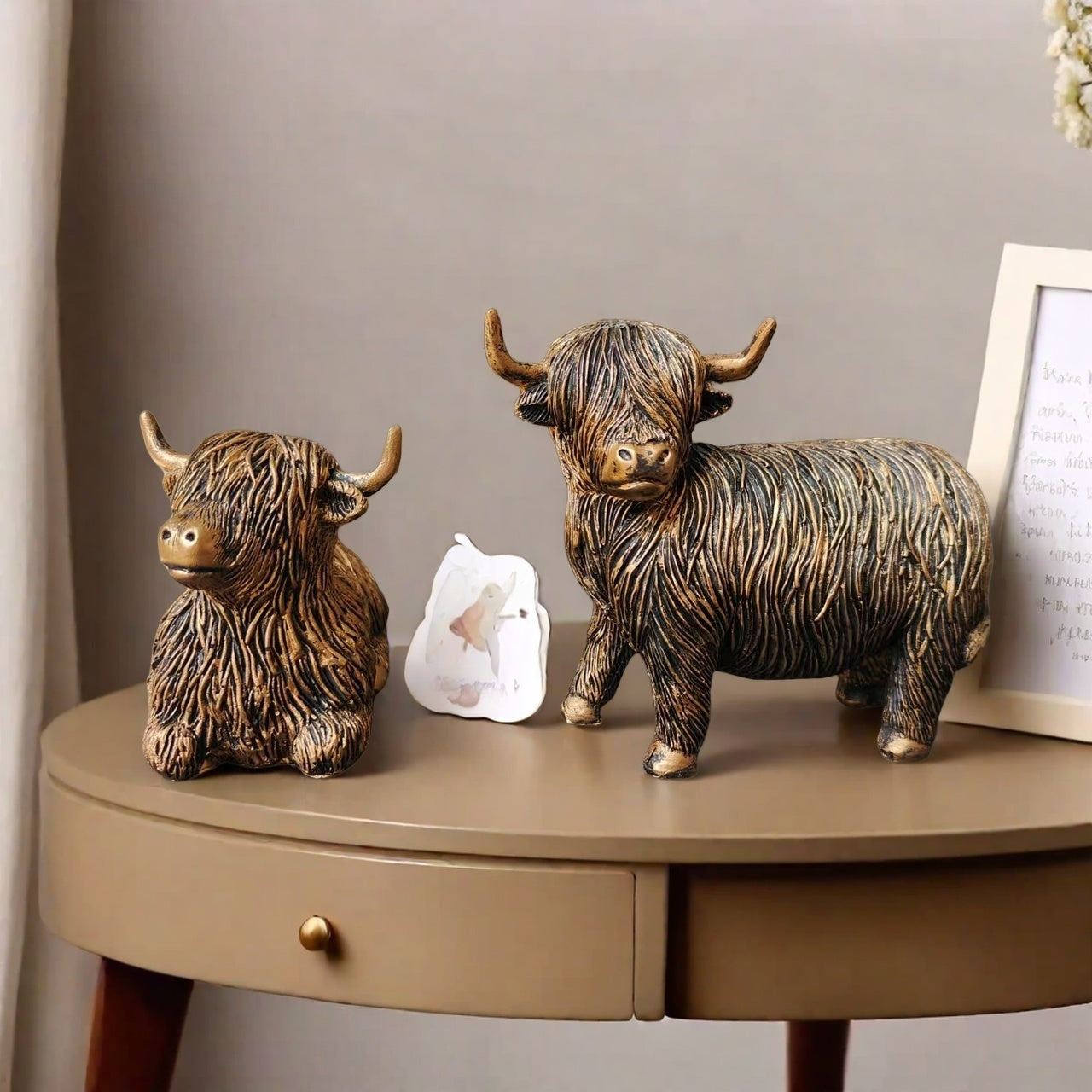 Eleganta skulpturer av höglandskon – Set med 2 figurer i harts med guldfärgad accentfinish