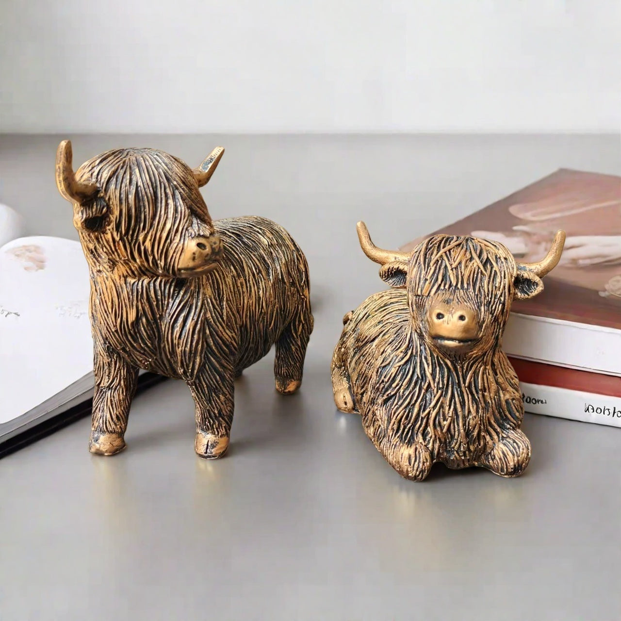 Eleganta skulpturer av höglandskon – Set med 2 figurer i harts med guldfärgad accentfinish