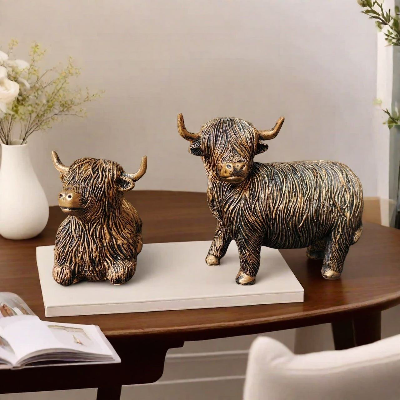 Eleganta skulpturer av höglandskon – Set med 2 figurer i harts med guldfärgad accentfinish