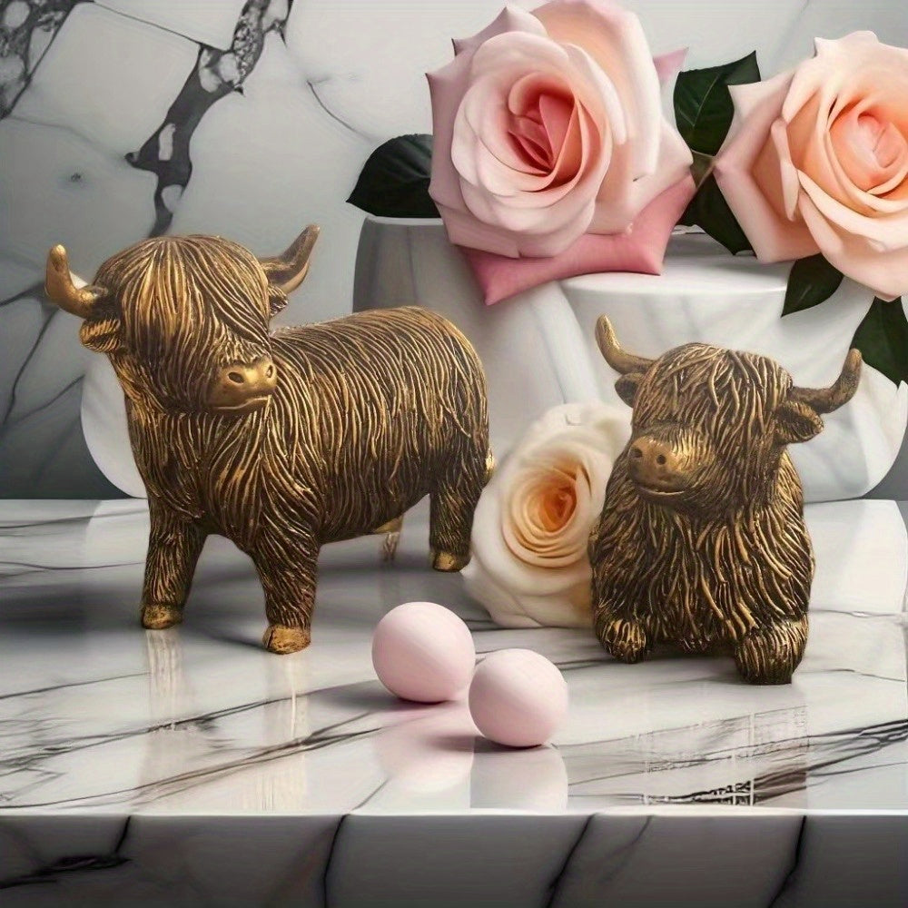 Eleganta skulpturer av höglandskon – Set med 2 figurer i harts med guldfärgad accentfinish