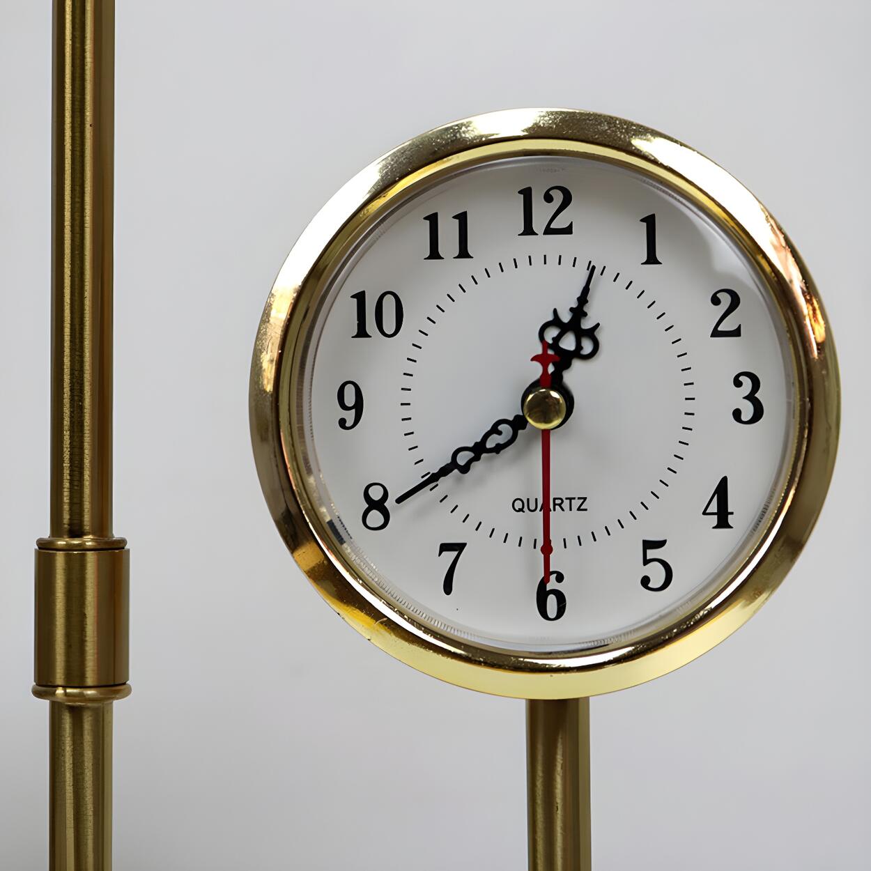 Modern guldfärgad bordslampa med glasglob och inbyggd klocka