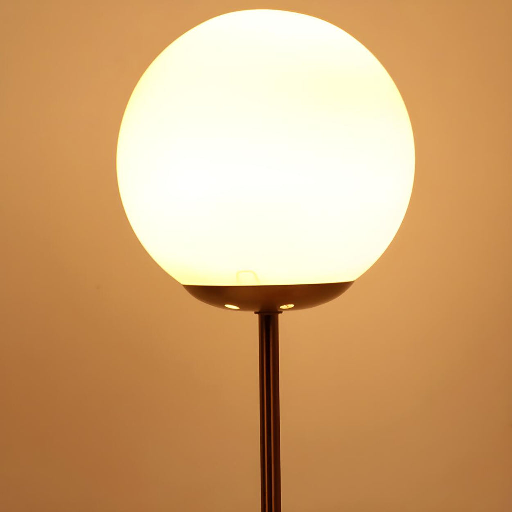 Modern guldfärgad bordslampa med glasglob och inbyggd klocka